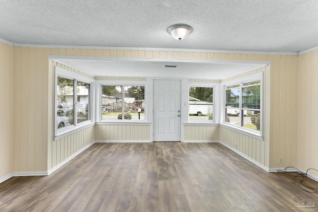 unfurnished room featuring wood finished floors, baseboards, and a textured ceiling