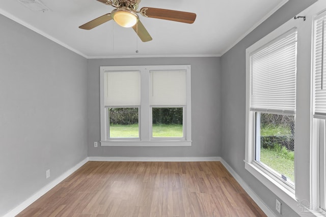 spare room featuring wood finished floors, baseboards, visible vents, and ornamental molding