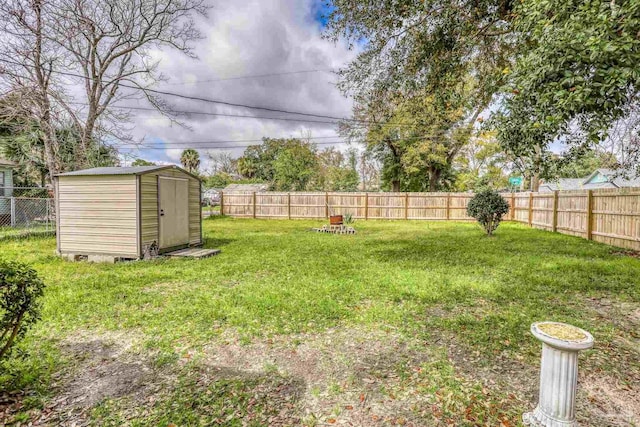 view of yard with a storage shed, a fenced backyard, and an outdoor structure