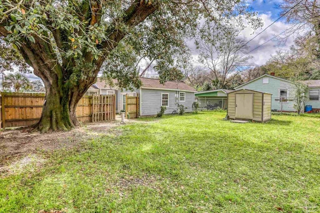 view of yard with an outdoor structure, a fenced backyard, and a shed