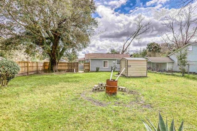 view of yard with a fenced backyard, a shed, and an outdoor structure