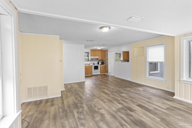 unfurnished living room with dark wood-type flooring, visible vents, and a textured ceiling