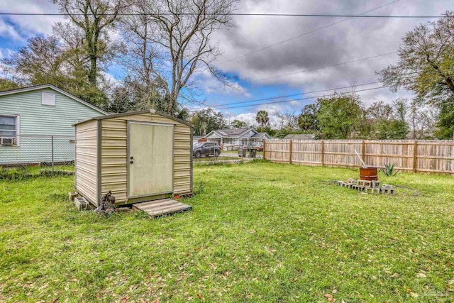 view of yard with an outbuilding, a fenced backyard, and a shed