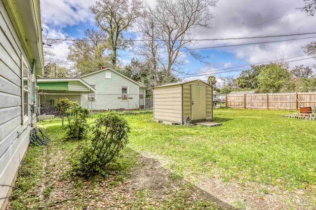 view of yard with an outbuilding, a shed, and fence