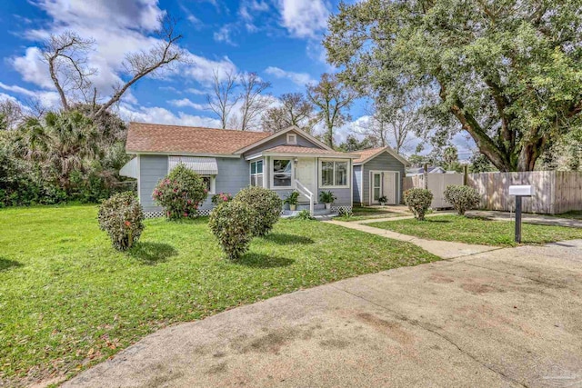 view of front of property featuring entry steps, a front yard, and fence