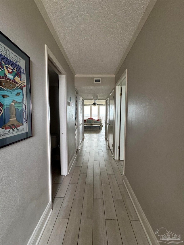 hall featuring a textured ceiling and light wood-type flooring