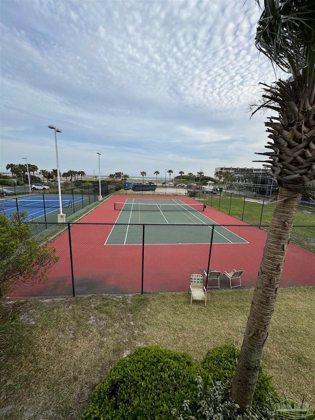 view of tennis court with a yard