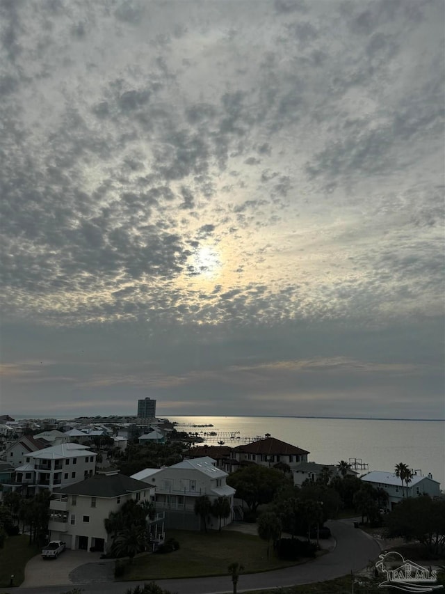 aerial view at dusk featuring a water view