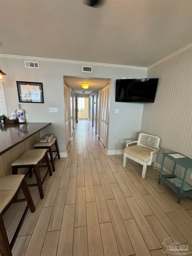 hall featuring light hardwood / wood-style flooring and ornamental molding