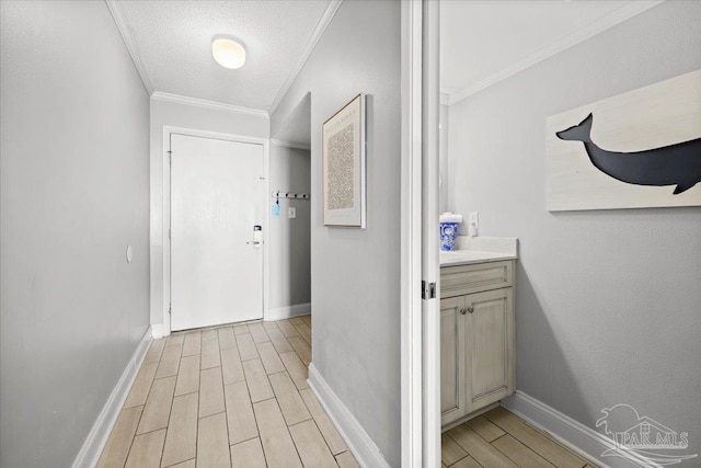 hallway with a textured ceiling, light wood-type flooring, and ornamental molding