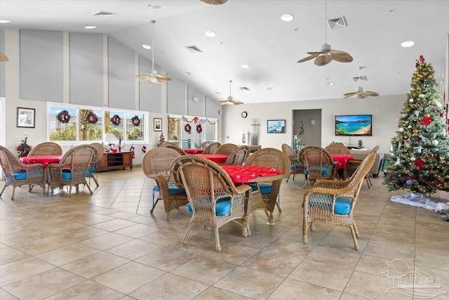 dining room with ceiling fan, high vaulted ceiling, and light tile patterned flooring