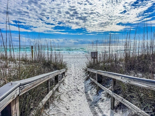 dock area featuring a water view and a beach view