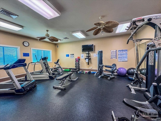 gym with ceiling fan and a healthy amount of sunlight