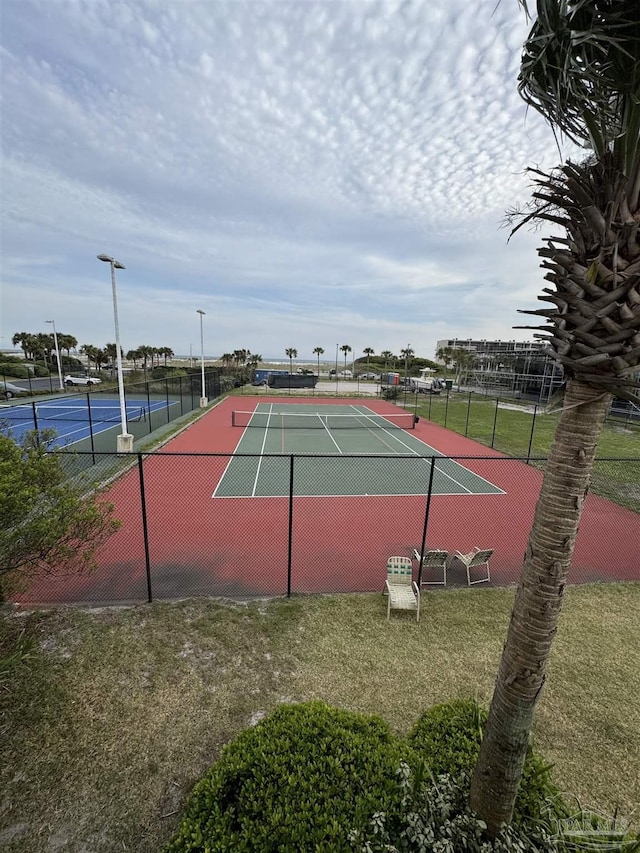 view of tennis court with a lawn