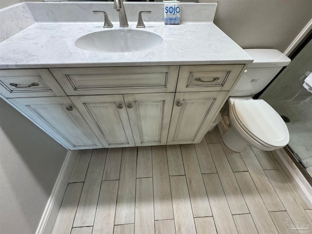 bathroom with vanity, wood-type flooring, and toilet