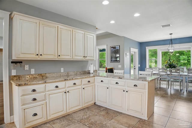 kitchen with cream cabinetry, recessed lighting, a peninsula, and a healthy amount of sunlight