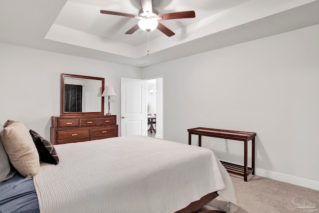 bedroom with carpet flooring, ceiling fan, and a raised ceiling