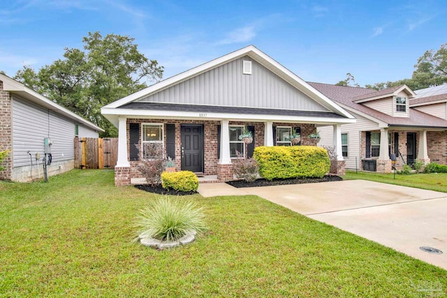 craftsman-style house with covered porch, a front yard, and central AC