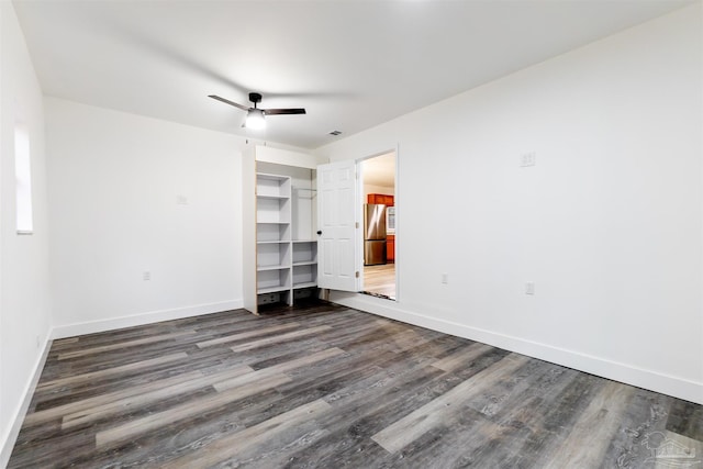 unfurnished bedroom featuring stainless steel refrigerator, ceiling fan, and dark wood-type flooring