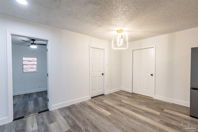 empty room featuring hardwood / wood-style flooring, ceiling fan, and a textured ceiling