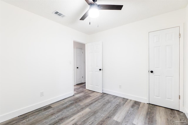 empty room with ceiling fan and light hardwood / wood-style flooring