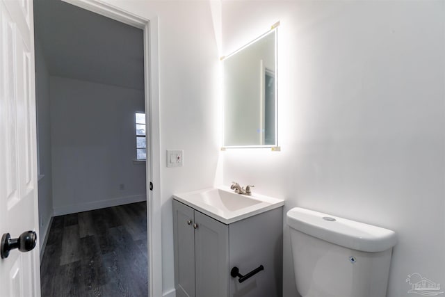 bathroom with hardwood / wood-style flooring, vanity, and toilet