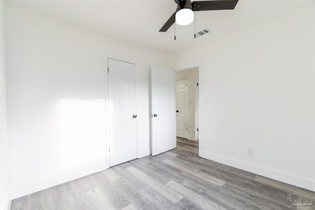 unfurnished bedroom with a closet, light hardwood / wood-style flooring, and ceiling fan