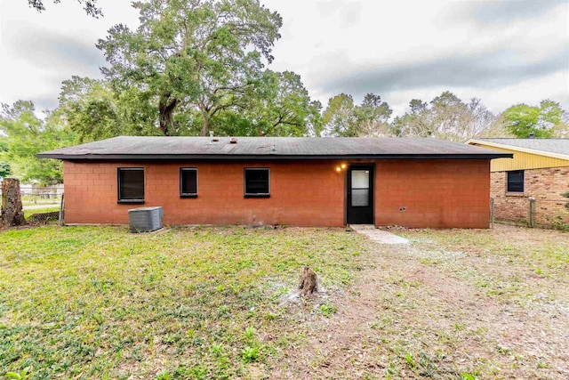 rear view of property featuring central AC and a yard