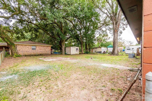 view of yard with cooling unit and a storage unit