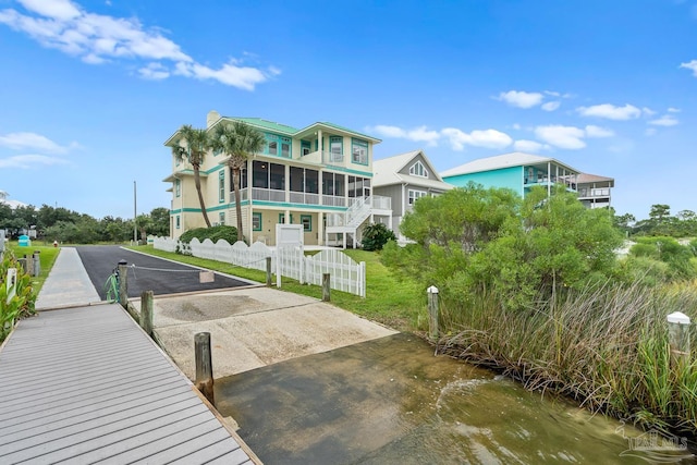 rear view of property with a water view and a sunroom