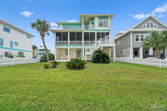 rear view of property featuring a sunroom and a yard