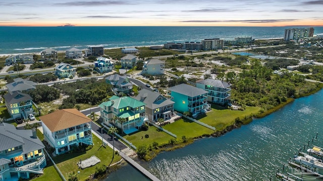 aerial view at dusk featuring a water view