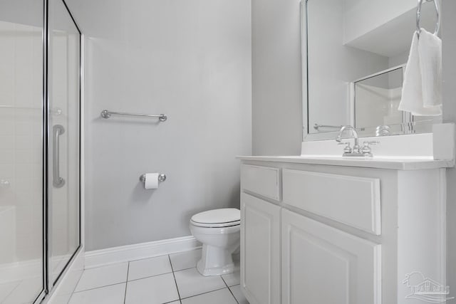 bathroom featuring tile patterned flooring, vanity, a shower with door, and toilet