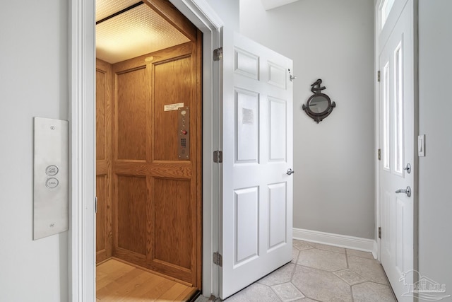 hall with elevator and light tile patterned floors