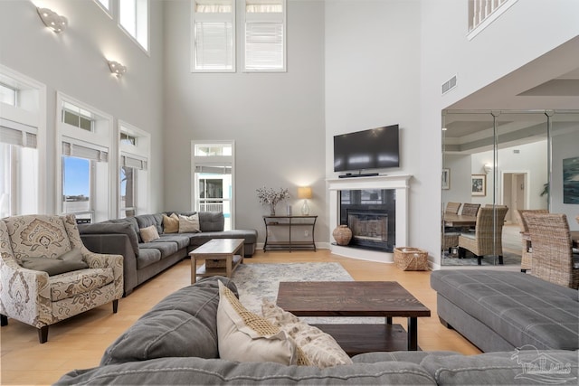 living room with a high ceiling and light wood-type flooring