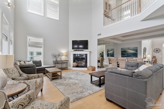 living room with hardwood / wood-style floors and a towering ceiling