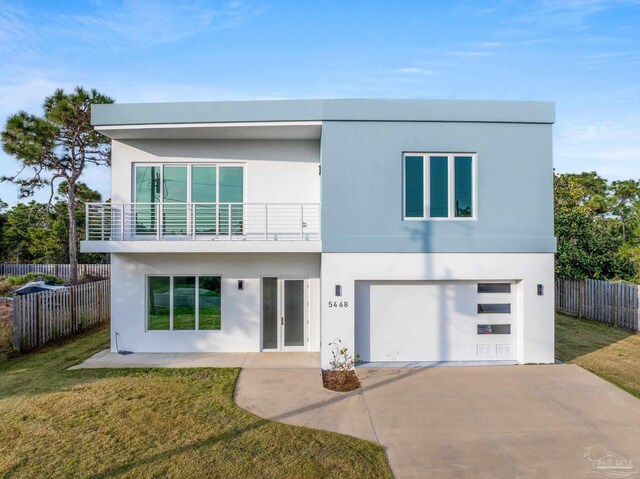 view of front facade with a balcony, a front yard, and a garage