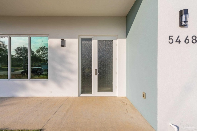 property entrance featuring a patio area and french doors