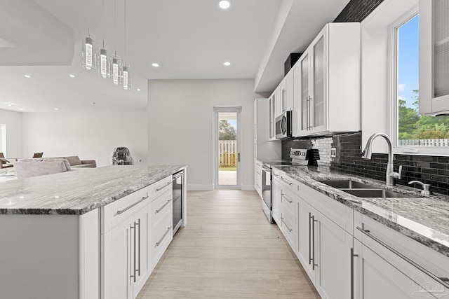 kitchen featuring white cabinets, light hardwood / wood-style floors, sink, and stainless steel appliances