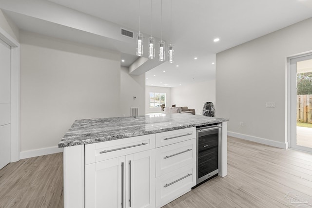 kitchen featuring wine cooler, a wealth of natural light, white cabinets, and light hardwood / wood-style floors