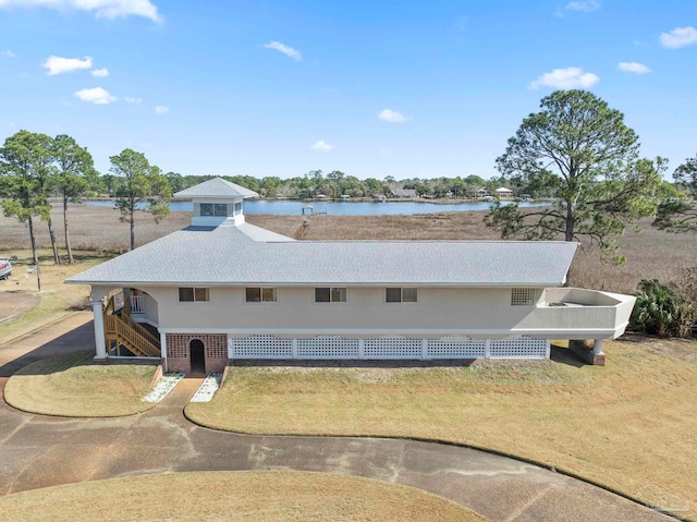 view of front facade featuring a front lawn and a water view