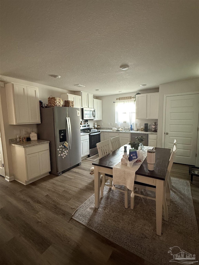 6312 June Bug Dr, Milton, FL 32583 - dining room featuring dark wood-style flooring and a textured ceiling