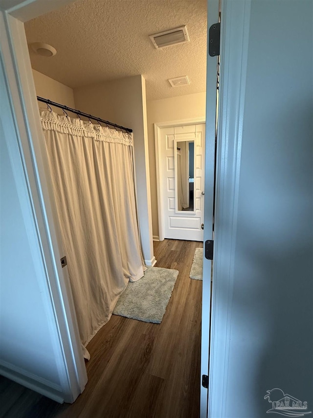 6312 June Bug Dr, Milton, FL 32583 - full bathroom featuring a shower with curtain, a textured ceiling, visible vents, and wood finished floors