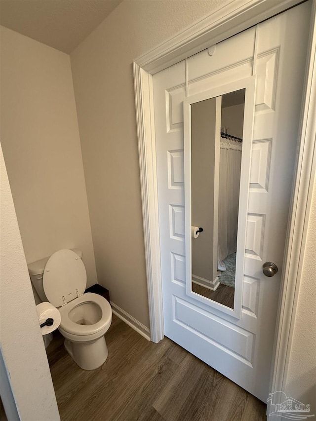6312 June Bug Dr, Milton, FL 32583 - bathroom featuring wood finished floors, toilet, and baseboards