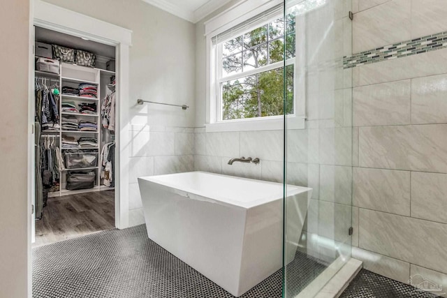 bathroom with tile patterned flooring, ornamental molding, separate shower and tub, and tile walls