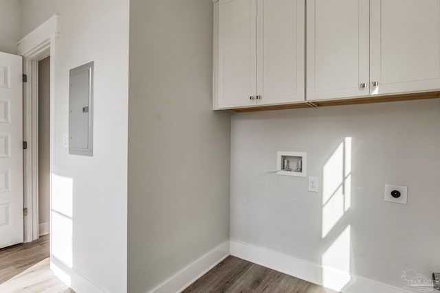 laundry area featuring hardwood / wood-style flooring, hookup for a washing machine, electric panel, cabinets, and hookup for an electric dryer