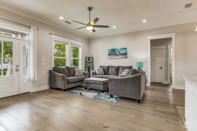 living room with ceiling fan, ornamental molding, and light hardwood / wood-style flooring