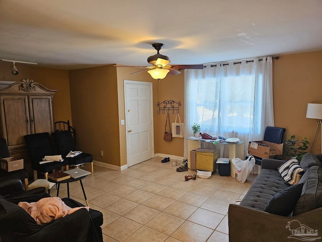 living area featuring ceiling fan, baseboards, and light tile patterned floors