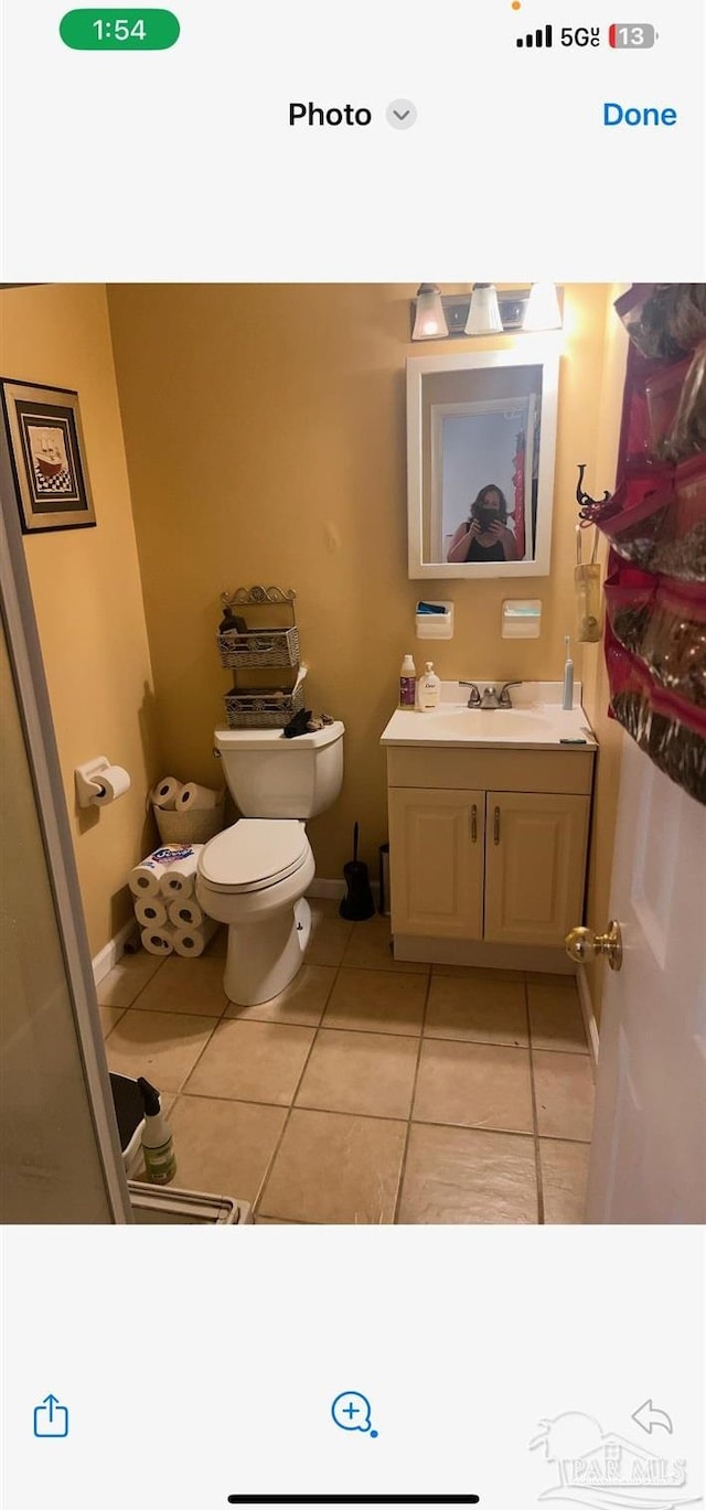 bathroom with toilet, tile patterned flooring, and vanity