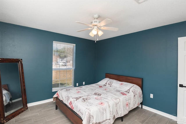 bedroom with baseboards, a ceiling fan, and wood finish floors